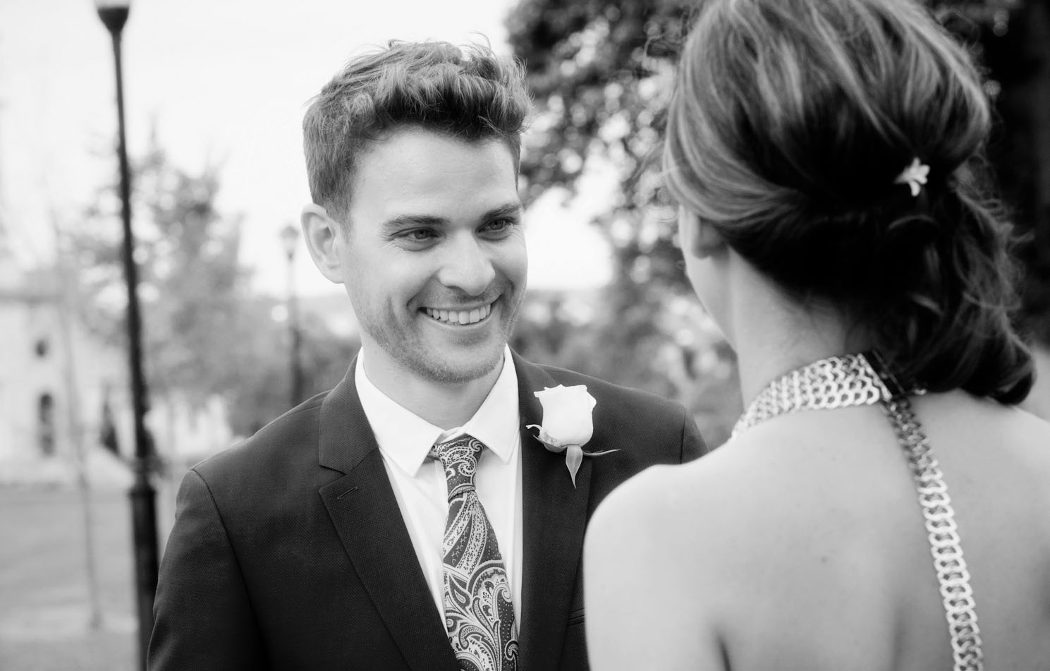 a groom looks lovingly at
					his bride